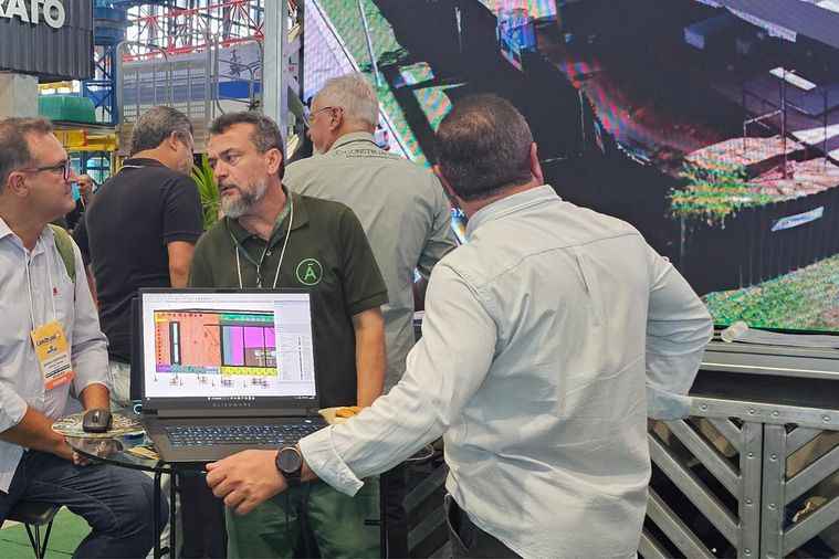 Técnico da ConstruÁgil a mostrar um modelo tridimensional num portátil a um
              visitante, junto a uma estrutura em light steel frame.