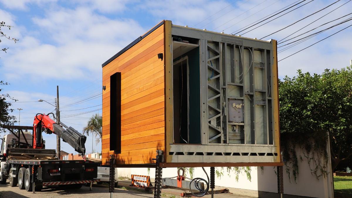 Módulo em light steel frame com revestimento de madeira a ser transportado sobre
              um camião com grua, já montado.